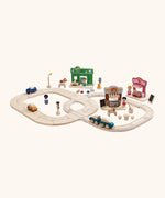 A small town setup made from different PlanToys wooden playsets including a rail road, bakery, vets and a ice cream shop