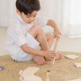 Child holding a loose wooden road piece from the PlanToys my first roadway set 