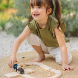 Child pushing a train on the wooden rail pieces from the PlanToys my first train set