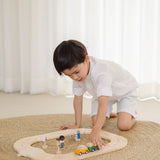 Child playing with the PlanToys my first wooden roadway set on a rug