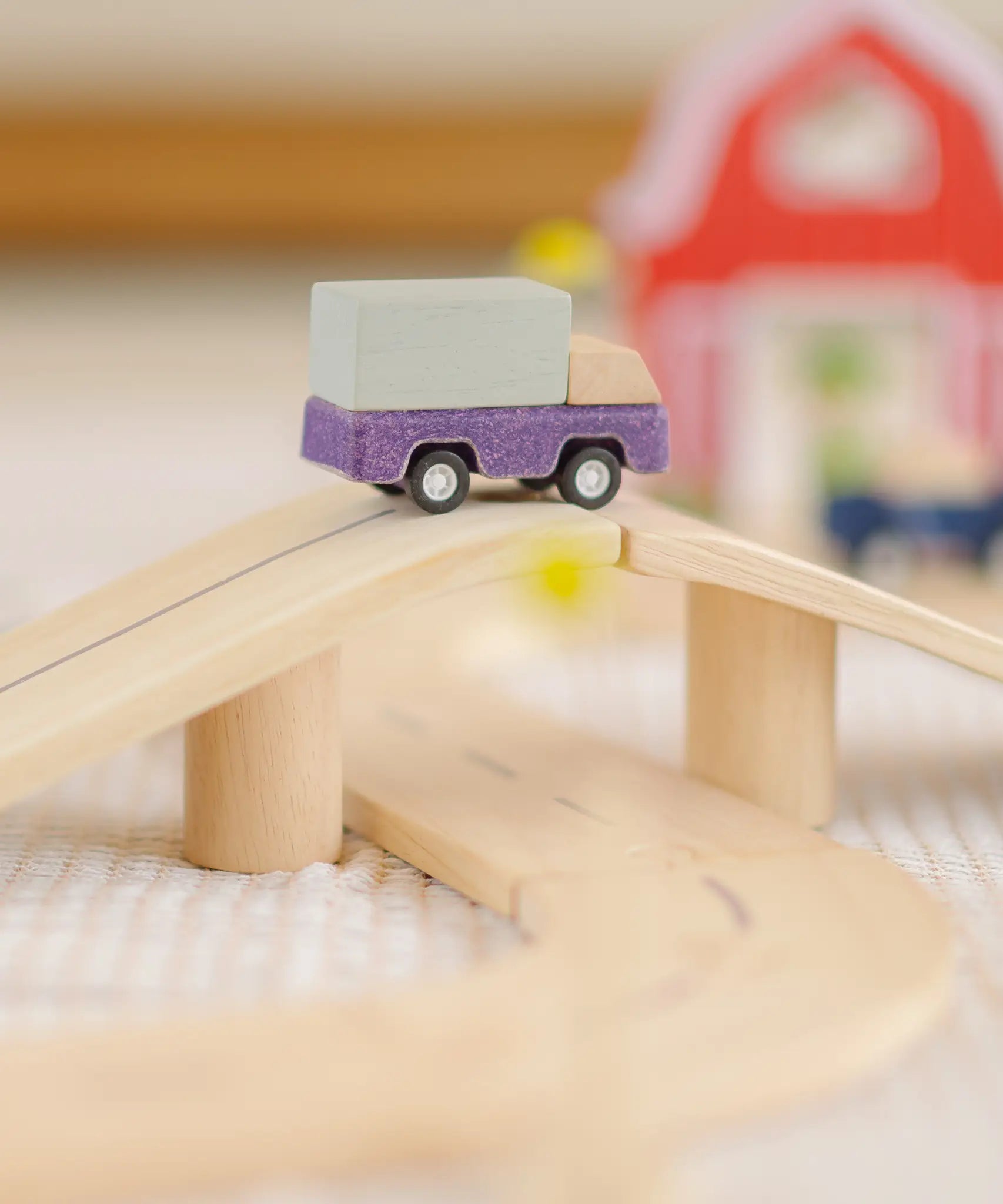 PlanToys wooden my little neighbourhood roadway playset showing a purple truck on a bridge