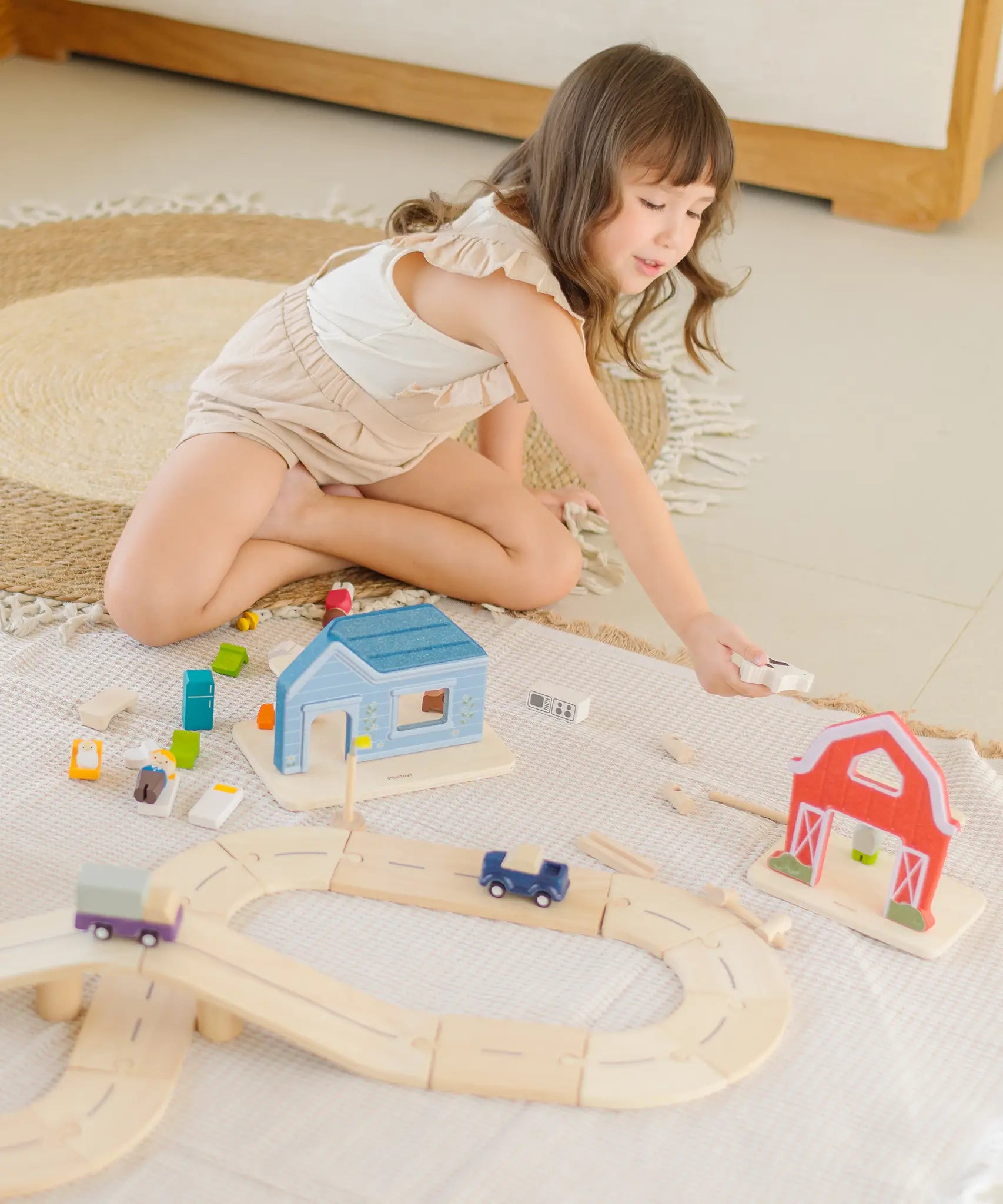 Child playing the farm pieces from the PlanToys my little wooden neighbourhood play set 
