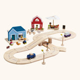 PlanToys my little neighbourhood roadway playset. Showing vehicles on wooden road pieces, market, home and a farm set
