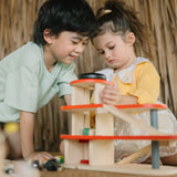 Children playing with the PlanToys wooden city parking garage using the wind up lift