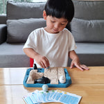 Child playing with the Plan Toys eco-friendly penguin themed family game on a wooden table