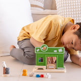 Child arranging different accessories on the PlanToys wooden pet shop