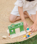 Child playing with the PlanToys pet shop play set showing the different animal figures 