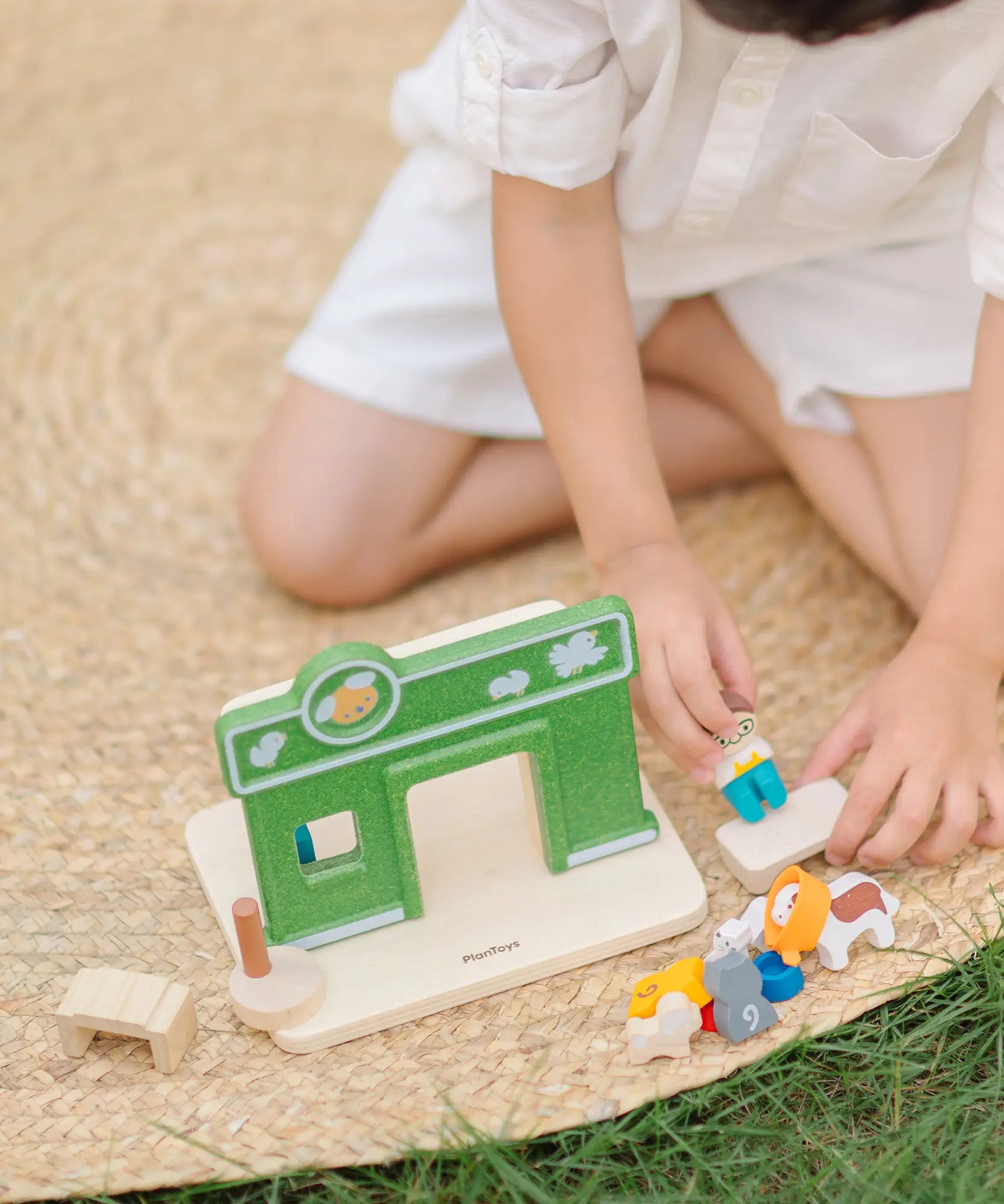 Child playing with the PlanToys pet shop play set showing the different animal figures 