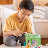 Child holding a shop keeper figure next to a PlanToys pet shop play set showing scale 