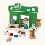 Loose animal and shop keeper  figures around the PlanToys wooden pet shop play set