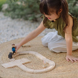 Child playing with the PlanToys my first train set in the garden