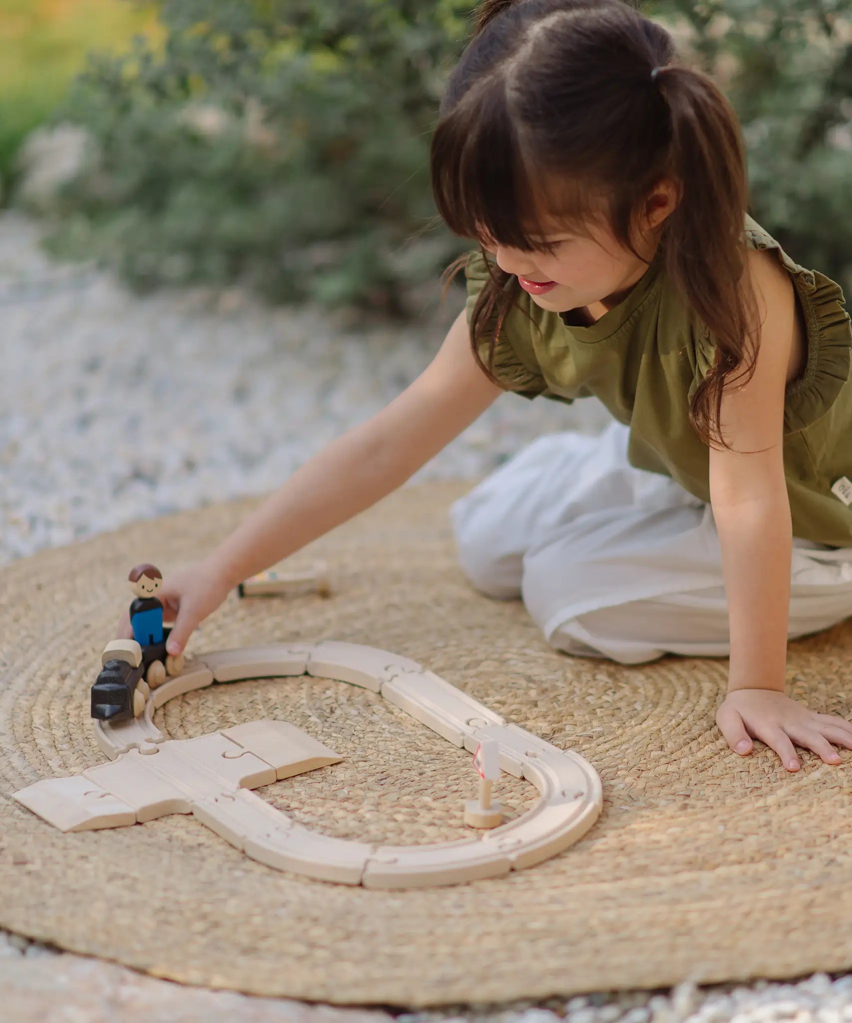 Child playing with the PlanToys my first train set in the garden