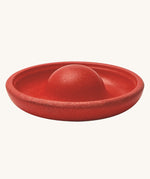 The red disk block from the PlanToys Creative Sand Play set, with a dome in the middle to allow for water to collect and run through
