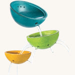 PlanToys Fountain Bowl Set, has three bowls made from PlanWood (a recycled rubber wood made by PlanToys). The bowls are blue, green and yellow, and have holes in the side and bottom to allow water to flow through, for a fun sensory experience. The image is on a cream background