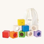 The PlanToys Activity Blocks set, is a wonderful, sensory experience for babies and toddlers. 9 different coluored blocks come with their own sensory part, which includes a differnt texture, sound and colour. These blocks can also be used for stacking games. The image is on a cream background.