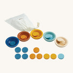 PlanToys Sort & Count Cups are a fun and educational toy for children. In the set are 5 bowls, in blue, orange, yellow, light blue and white, with 5 round disks for each bowl in the same colours. The image is on a cream background.