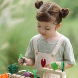 Planting beds from the PlanToys stack & sprout set with a child inserting loose veg pieces