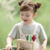 Child sorting loose veg piece into  planting beds from the PlanToys stack & sprout set 