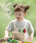 Child sorting loose veg piece into  planting beds from the PlanToys stack & sprout set 