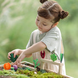 Child inserting loose veg pieces on planting beds from the PlanToys stack & sprout set
