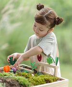 Child inserting loose veg pieces on planting beds from the PlanToys stack & sprout set