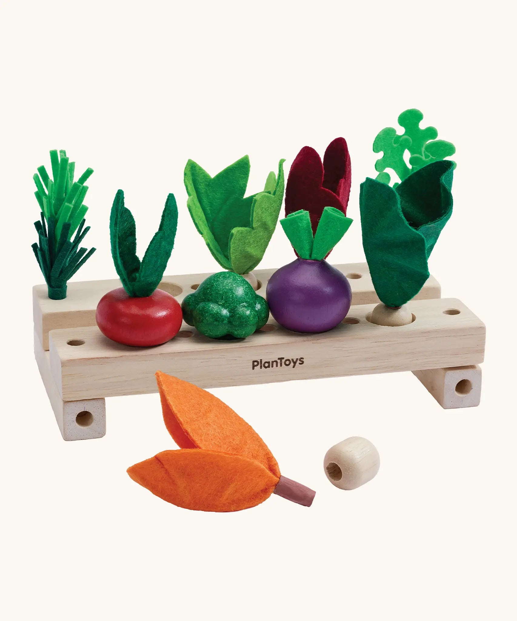 PlanToys stack & sprout set showing different veg on top of the wooden planters and a loose veg piece
