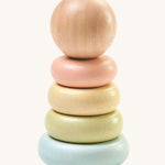 PlanToys Pastel First Stacking Ring, is a perfect first stacking ring for babies and little ones. The stacking rings are on a pastel blue base, and the ring colours are pastel green, pastel yellow, and pastel peach. On top is a natural wooden ball which can be used as a rolling toy. The image is on a cream background