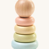 PlanToys Pastel First Stacking Ring, is a perfect first stacking ring for babies and little ones. The stacking rings are on a pastel blue base, and the ring colours are pastel green, pastel yellow, and pastel peach. On top is a natural wooden ball which can be used as a rolling toy. The image is on a cream background