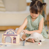 Child playing with the PlanToys wooden train station on its own.