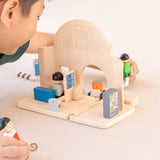 Back of the PlanToys train station showing the rail piece running underneath. Child holding people figures