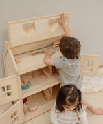 Child lifting the working roof showing the attic on the PlanToys Victorian dolls 