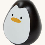This PlanToys Penguin is a sweet wooden tumbling toy that wobbles and spins. Its size is perfect for little hands, and its smooth texture is perfect for gripping. This wobbling penguin toy is black, with a white face, black eyes and orange beak. The image is on a cream background