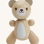 PlanToys Little Bear is an adorable wooden teady bear toy, which is perfect for babies and little ones. The smooth design of the teddy means little ones can get a good grip on the teddy. The teddy has a white patch on its belly and a smiling face. The image is on a cream background.