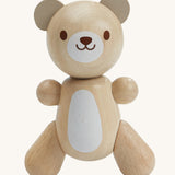 PlanToys Little Bear is an adorable wooden teady bear toy, which is perfect for babies and little ones. The smooth design of the teddy means little ones can get a good grip on the teddy. The teddy has a white patch on its belly and a smiling face. The image is on a cream background.