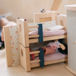 A closer look at a doll sleeping in the bottom bunk bed