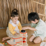 Children playing with the PlanToys wooden city parking garage 
