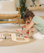 Child playing with a vehicles and the carpark from the PlanTous city transit rail and road playset