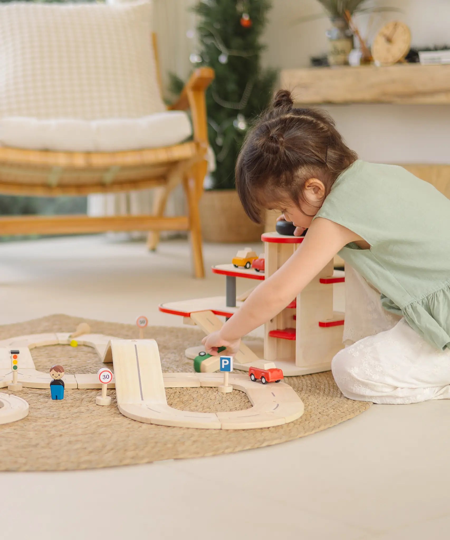 Child playing with a vehicles and the carpark from the PlanTous city transit rail and road playset