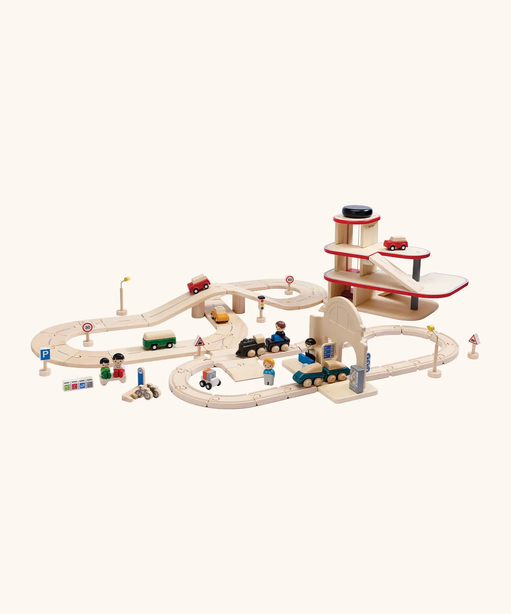 A city play setup made from PlanToys wooden rail and road pieces, train station and a carpark. 