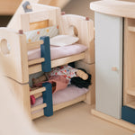 A closer look at a doll sleeping in the bottom bunk bed