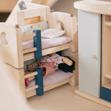 A closer look at a doll sleeping in the bottom bunk bed