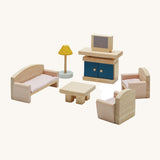 Plan Toys Living Room Dolls House Furniture Set, featuring Wooden chairs, a sofa, a coffee table, a lamp and a TV with a TV unit. On a cream background