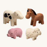 The PlanToys Farm Animals Set come with four adorable figures which include a pink pig, a white cow with black spots, a brown horse and a white sheep. The image is on a cream background