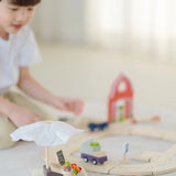 PlanToys market stall set standing next to a roadway