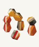 PlanToys Geo Stacking Rocks, are a colourful set of wood blocks with geometric rock shapes. The rocks are striped and are mustard, cream, red and grey in colour. The image is on a cream background