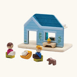 PlanToys wooden blue house set showing wooden family figures sitting on furniture 