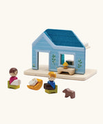 PlanToys wooden blue house set showing wooden family figures sitting on furniture 