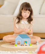 Child playing with the the PlanToys wooden blue house set 