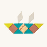 A boat made from the shapes of the PlanToys Mini Mosaic Blocks, on a cream background