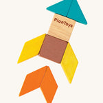 A rocket ship made from the shapes of the PlanToys Mini Mosaic Blocks, on a cream background